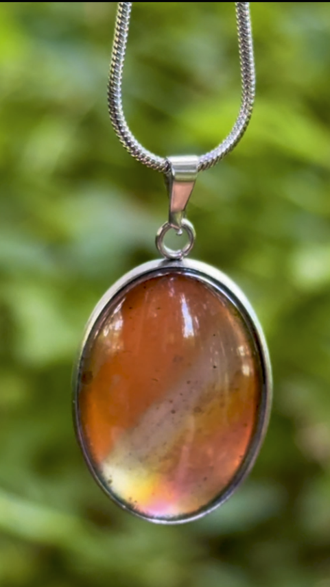 Torchbearer Twelve Specimen Ten wearable copper specimen pendant displaying vivid orange, gold and iridescent copper tones that resemble a miniature solar flare preserved beneath glass.