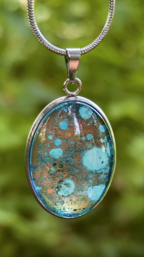 Torchbearer Twelve Specimen Three wearable copper specimen pendant featuring turquoise verdigris blooms scattered across an aged copper surface, creating the appearance of a miniature mineral field.