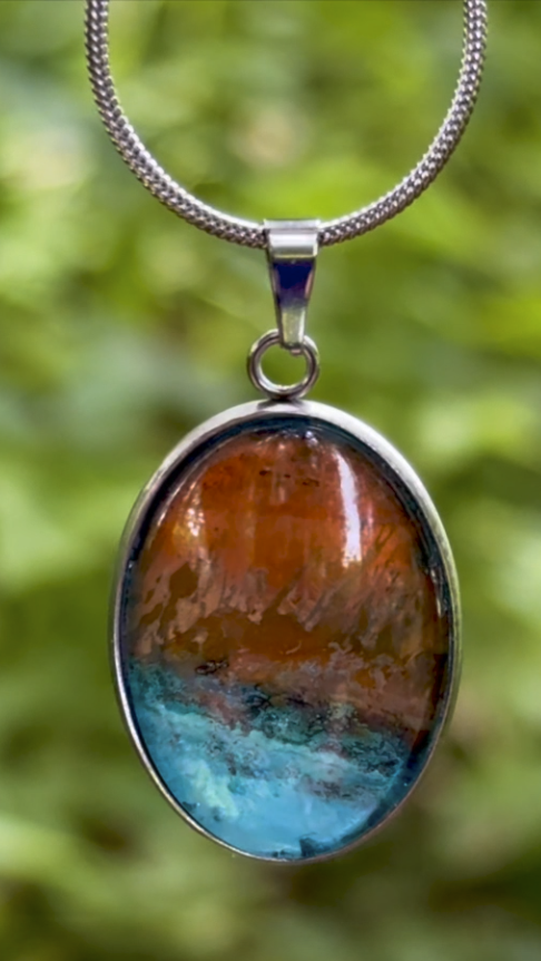 Torchbearer Twelve Specimen Four wearable copper specimen pendant displaying bright turquoise and amber-gold formations reminiscent of sunlit mountains and an azure sea, preserved between glass and stainless steel.