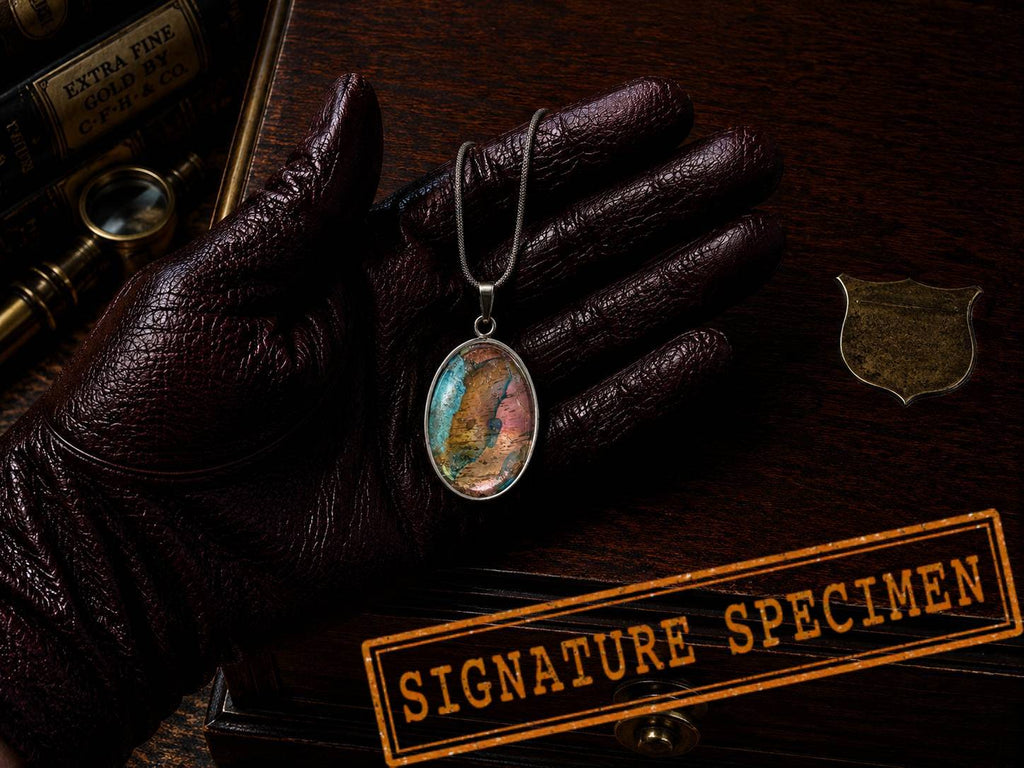 Torchbearer Twelve Specimen Nine wearable copper specimen pendant featuring layered verdigris blues and copper-gold striations reminiscent of an ancient geological map.