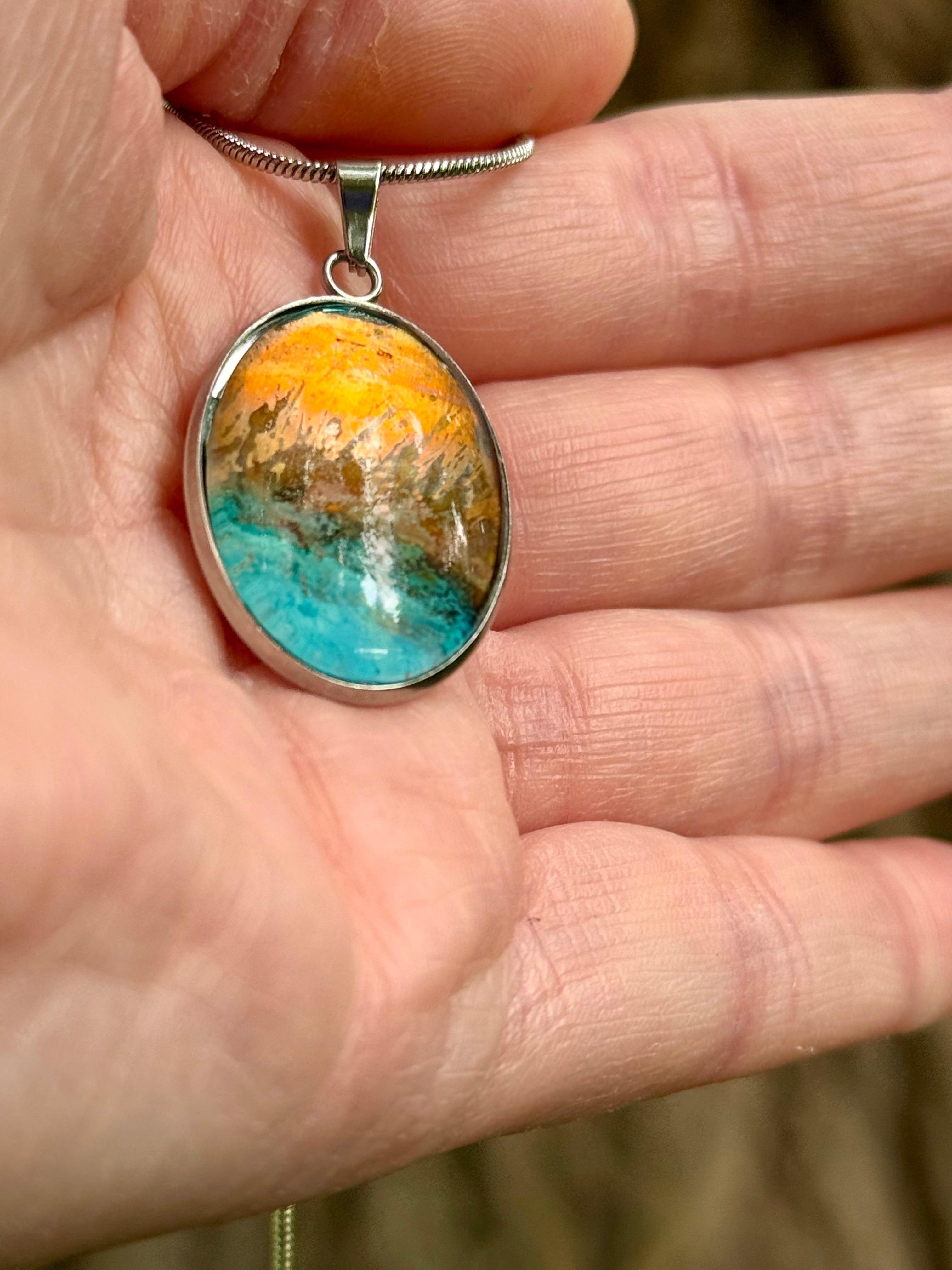 Torchbearer Twelve Specimen Four wearable copper specimen pendant displaying bright turquoise and amber-gold formations reminiscent of sunlit mountains and an azure sea, preserved between glass and stainless steel.