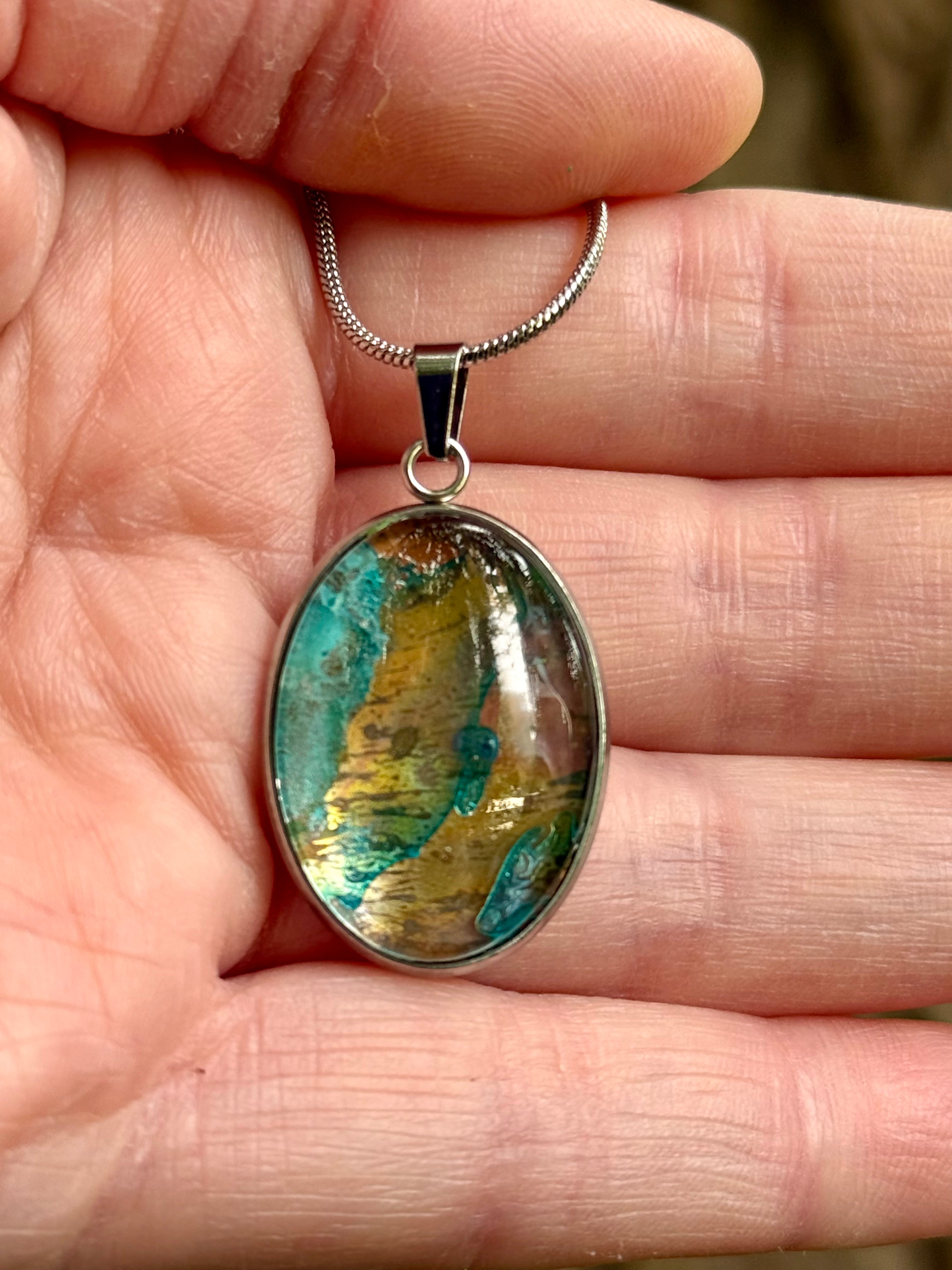 Torchbearer Twelve Specimen Nine wearable copper specimen pendant featuring layered verdigris blues and copper-gold striations reminiscent of an ancient geological map.